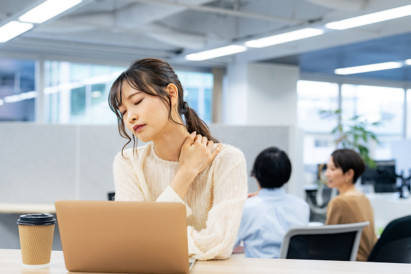 肩を押さえる女性