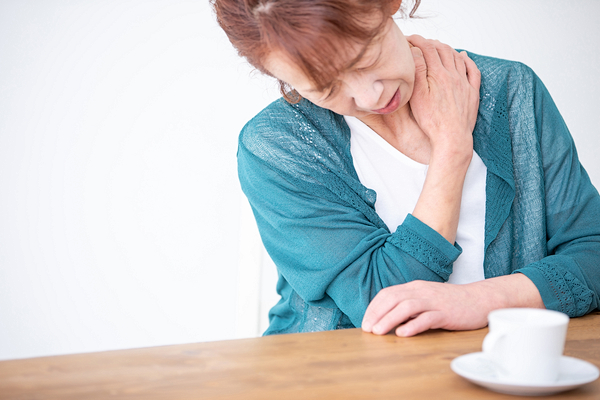 肩を押さえる女性