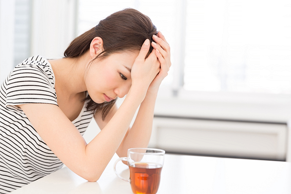 頭を抑える女性