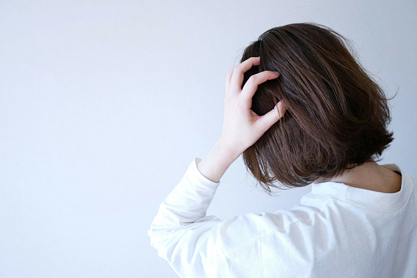 頭を押さえる女性